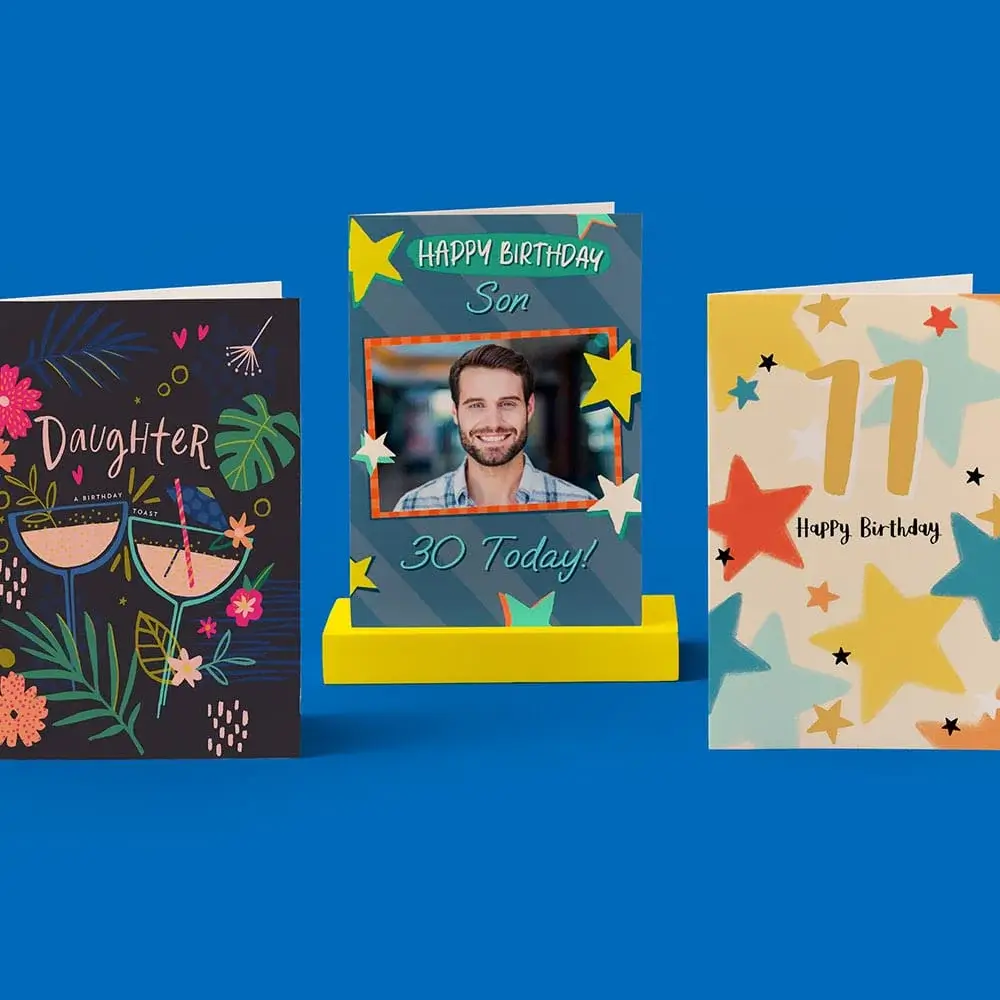 Three colorful birthday cards displayed on a blue background, including designs for a daughter, a son, and an 11th birthday, featuring vibrant patterns and star motifs.